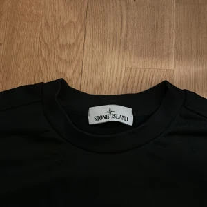 Svart tröja från Stone Island - Säljer en stilren svart tröja från Stone Island med en liten röd detalj på framsidan och texten 'Stone Island Marina' på baksidan. Perfekt för en casual look.9/10 skick knappt använd. Ny pris 3000 mitt pris 499