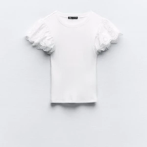 Vit topp från zara - Säljer en söt vit ribbad topp från Zara med korta ärmar och spetsdetaljer. Knappt används så i bra skick❣️