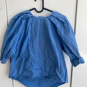 Blå blus med puffärmar  - En fin blå blus med puffärmar som är perfekt för en varm sommar dag eller en vårig fest. På bilden är det inte stryck och denna är väldigt skön och luftig. Pris kan diskuteras