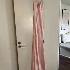 Balklänning - Rosa klänning med knyten i ryggen. (Samma som på andra bilden fast i rosa färg) använd endast en gång så i fint skick! 