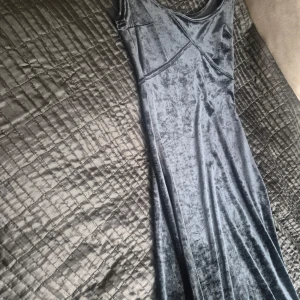 Svart långklänning i sammet från Chic Fille - Säljer en elegant svart långklänning i mjuk sammet från Chic Fille Paris. Klänningen har smala axelband och en figurnära passform som framhäver siluetten. Perfekt för dig som vill ha en stilren och klassisk look.