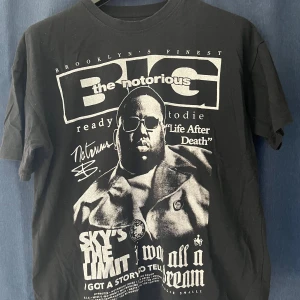 Svart t-shirt med The Notorious B.I.G. tryck från Pull&Bear - Cool svart t-shirt från Pull&Bear med stort tryck av The Notorious B.I.G. på framsidan. T-shirten har klassisk passform, rund hals och korta ärmar. Perfekt för dig som gillar hiphop och streetwear.