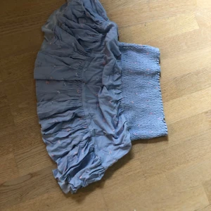 Ljusblå kort volangkjol - Ljusblå kort volangkjol med små blommor som mönster. Köpt på lager 157 för ca ett halvår sedan men har bara anspänt några få gånger.