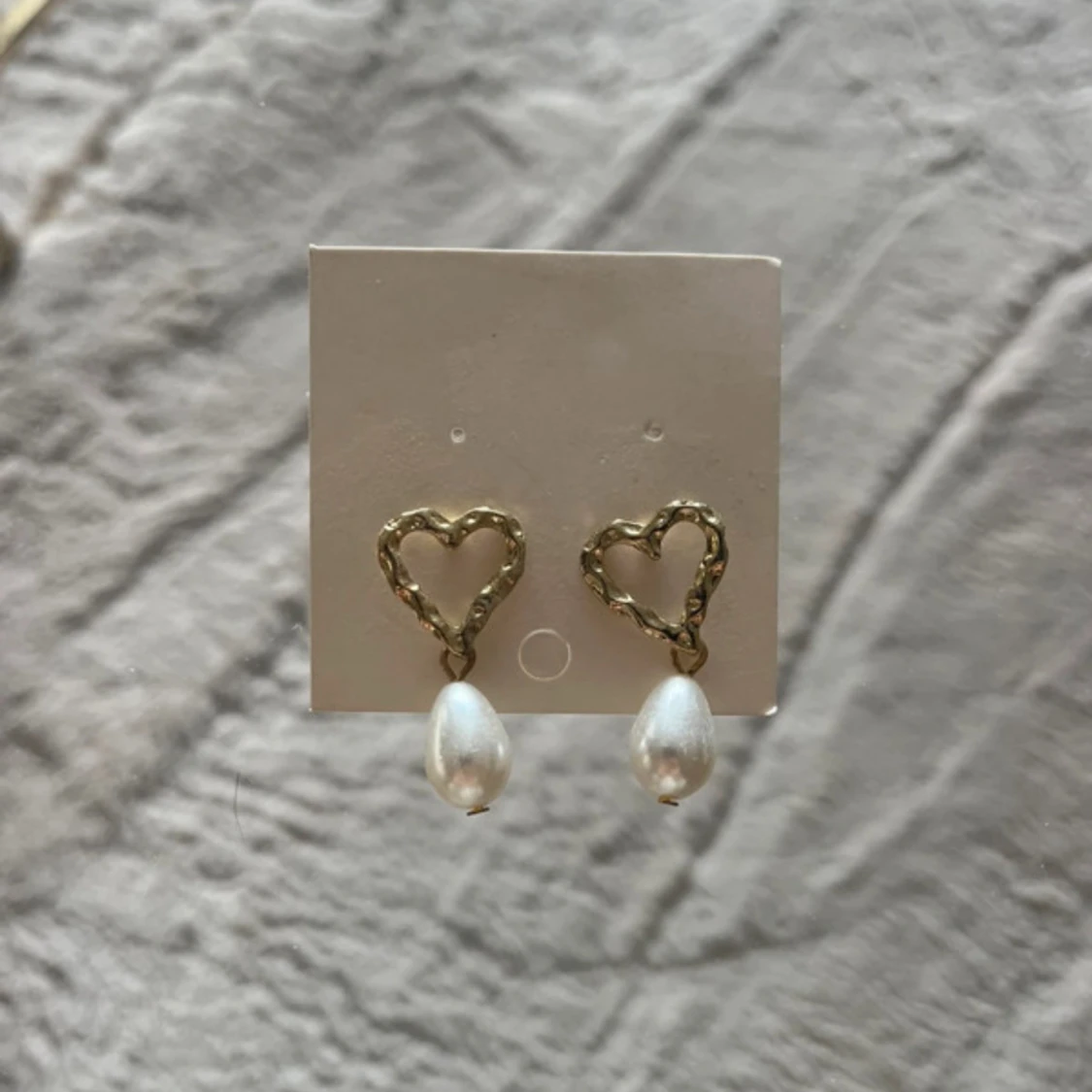 Guldiga hjärtformade örhängen med pärlor