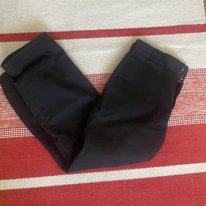 Svarta Dickies 874 Original Fit byxor - Klassiska svarta Dickies 874 Original Fit byxor med rak passform och normal midja. Perfekta för en clean och stilren look, tillverkade i slitstarkt material. Passar både till vardags och när du vill vara extra snygg. 31x32