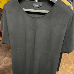 Zizzi klänning gråsvart i stl S - Enkel gråsvart klänning från Zizzi med rund halsringning och korta ärmar. Klänningen har en rak passform och är tillverkad i ett mjukt material som ger en stilren look. Perfekt för dig som gillar minimalistisk stil.