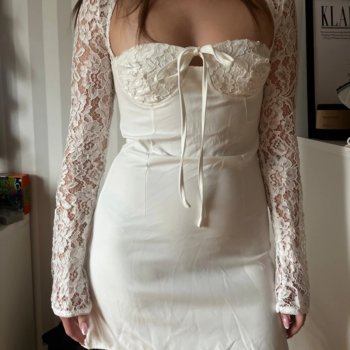 Vit spetsklänning med långa ärmar och knytning