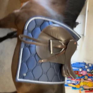 Marin blått schabrak för häst från PS of Sweden - Snyggt marin blått schabrak  från PS of Sweden med broderad logga framtill och dekorativ kant i silver. Materialet är syntet och bomull. Aldrig ridit med för min häst är en travare. Storlek full i båda. 