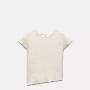 Vit topp med knytning i ryggen - Aldrig använd Zara topp. Supermjuk och fluffig vit topp med korta ärmar och snygg knytning i ryggen. Asymmetrisk nederkant och justerbara snören i ryggen❤️ säljer då den inte passar mig💗😚 ordinarie pris 250