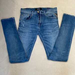 Replay jeans - Säljer ett par blå Replay Jondrill som är samma som anbass ända skillnaden är utseendet på höger framficka. Dem är slim fit och har ett par feta slitningar. Tveka inte på att höra av er vid frågor eller funderingar.