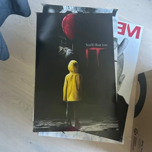 IT-film affisch - Säljer en stor affisch från skräckfilmen IT. Motivet visar en person i gul regnjacka som står framför en röd ballong och texten 'You'll float too.' Perfekt för dig som gillar skräck och vill ha något coolt på väggen.
