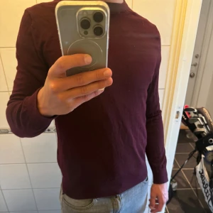 Vinröd långärmad tröja - Säljer en vinröd långärmad tröja från Riley med rund hals. Tröjan har en enkel och stilren design, perfekt att matcha med jeans eller andra byxor. 100% merino ull tröjan är aldrig använd mer än testad i butik. Storleken är M men passar även S Hör av er för eventulla frågor!! 