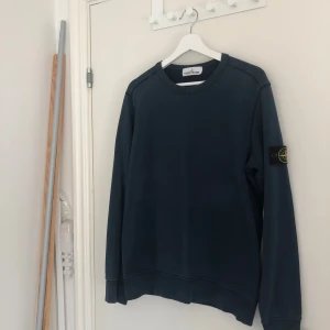 Blå tröja från Stone Island - Säljer en snygg blå tröja från Stone Island. Tröjan är i bra skick och har det ikoniska Stone Island-märket på ärmen. Tröjan är i M men är lite liten i storleken så passar båda M och S. Det är bara att skriva om ni har några funderingar. Självklart äkta!!!