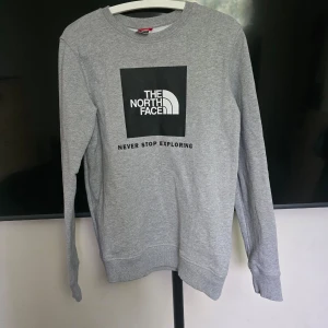 Grå sweatshirt från The North Face - Oanvänd utan lapp . Säljer en grå sweatshirt från The North Face i storlek XXL .ungdom170/176. Herrstorlek ca . Xs/S . Tröjan har rund halsringning, långa ärmar och tryckt logga framtill samt liten logga på baksidan.  Perfekt för en avslappnad stil. 