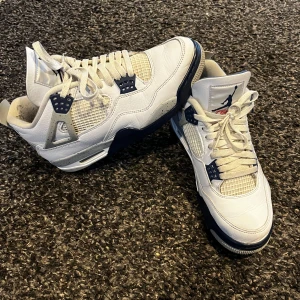 Nike Air Jordan 4 Retro sneakers “midnight navy” - Säljer ett par Nike Air Jordan 4 Retro sneakers i vitt och marinblått. Skorna har klassisk meshpanel, snörning och Jumpman-logga på plösen. Perfekta för dig som gillar streetwear och vill sticka ut med en ikonisk modell. Väldigt sköna att ha på sig och använt de några gånger. Dm för några funderingar! 