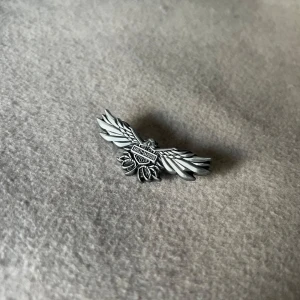 Harley Davidson Freedom Flight Pin - Klassisk Harley Davidson-pin med örnmotiv – en ikonisk symbol för frihet och vägar utan slut. Perfekt att fästa på jackor, väskor eller västar. Mått: ca 5,3 cm lång och 1,7 cm bred
