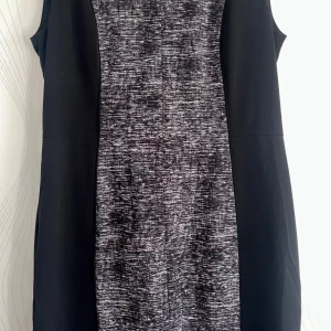 Svart och grå mönstrad klänning H&M - Snygg ärmlös kortklänning från H&M i svart med gråmelerat mönster framtill. Klänningen har en rak passform och är tillverkad i ett mjukt, stretchigt material som känns bekvämt hela dagen. Perfekt för dig som gillar stilren design med en twist.