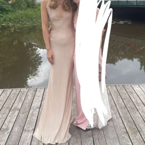 Balklänning - Jättesöt beige/rosaaktig balklänning med öppen rygg. Fint och skönt material.  Använd 1 gång Storlek S/jag är 176, lite smuts längst ner 