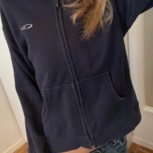 Supersöt vintage champion hoodie - Mysig marinblå fleecejacka med hel dragkedja framtill och två stora fickor. Jackan har en enkel design med diskret logga på bröstet och långa ärmar. Perfekt för lager-på-lager och chill dagar. Den är i perfekt skick och är storlek M i barn vilket motsvarar XXS i vuxen storlek. 
