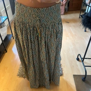 Mönstrad långkjol  - Säljer en flowy långkjol med smockad midja och snyggt bohemiskt mönster i grönt och beige. Kjolen är endast använd ungefär 5 ggr totalt och är i väldigt bra skick, köpt på Zara!