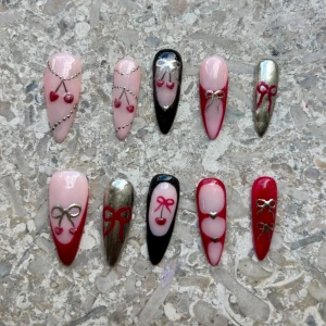 Handgjorda Coquette Press on-naglar || S - Set med 10 stiletto press on-naglar i rosa, rött, svart och silver. Dekorerade med 3D-rosetter, körsbär, hjärtan och silvriga detaljer. Handgjorda av mig!