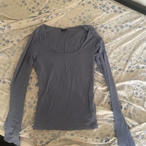 Långärmad topp Gina Tricot - Ljus blå ginatricot topp med slit.  Använd 1-2 gånger men ser helt ny ut.  Säljer den för den var inte min stil💕💕