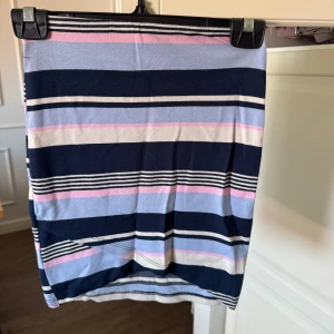 Randig kortkjol  - Säljer en söt kortkjol med breda ränder i marinblått, ljusblått, rosa och vitt.