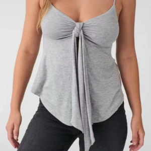 Grå knytlinne från Gina Tricot - Supersnygg grå linnetopp från Gina Tricot med smala axelband och knyt framtill. Toppen har en lätt utsvängd passform och är tillverkad i mjuk bomullsblandning. Säljer då det aldrig kommer till användning (helt nytt). Nypris: 260