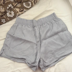 Ljusgrå shorts i lyocell från HM - Ljusgrå korta shorts i lyocell. 