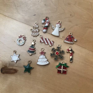 Juliga berlocker i emalj och metall - Säljer 13 stycken färgglada julberlocker i emalj och guldfärgad metall. Motiven är bland annat julgran, snöflinga, pepparkaka, ängel, polkagris, paket och stjärna. Färgerna är röd, grön, vit, guld och inslag av glitter. Perfekta som hängen till halsband, armband eller örhängen. Priset gäller för alla berlocker💞