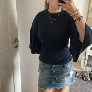 Mörkblå blus med vida ärmar Wacay XS - Säljer en mörkblå blus från Wacay i storlek XS. Blusen har rund halsringning och vida, trekvartsärmar som ger en snygg och trendig siluett. Perfekt att styla med jeans eller kjol för en cool look.