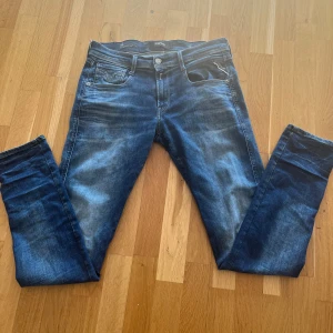 Replay anbass hyperflex - Snygga blå Replay Anbass jeans med klassisk femficksdesign och lätt slitna detaljer. Använda ett fåtal gånger. Jeansen har smal passform och är tillverkade i stretchig bomullsdenim för extra komfort. Perfekta för dig som gillar en modern och stilren look.