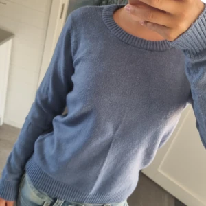 Blå stickad tröja från Vila XS - Mysig blå stickad tröja från Vila i storlek XS. Tröjan har rund halsringning, ribbade muddar vid ärmslut och nederkant samt lång ärm. Perfekt att slänga på sig till jeans för en chill look.