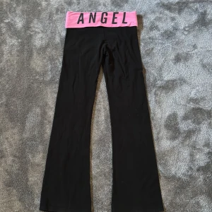  yoga pants från Victoria's Secret - Svarta yoga pants med rosa midja från Victoria’s Secret. Byxorna är  bootcut och i använt men fint skick. I strl Xs men passar även S