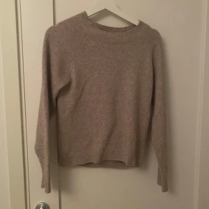 Beige stickad tröja från Vero Moda - Mysig beige stickad tröja från Vero Moda i storlek XS. Tröjan har rund halsringning, ribbade muddar och lång ärm. Perfekt för lager-på-lager och passar till både jeans och kjol. Enkel och stilren design som funkar till allt.