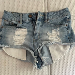 jeansshorts  - Snygga ljusblå jeansshorts med slitna detaljer och fransig kant. Det är stolen S men passar mer XS💕 Skriv för frågor 💖