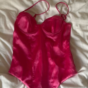 Rosa body från Zara - Supersnygg rosa body från Zara med tunna axelband och har sidenliknande material. Endast använd en gång så är i väldigt fint skick!