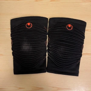 Uhlsport Knäskydd - 2 st knäskydd från Uhlsport använda en gång i fotbollsträning.  Storlek M. Medium: bredden överst 14 cm, bredden nederst 11 cm, längden 24 cm. Kan hämtas i Vallentuna.