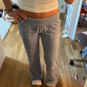 Ljusblå juicybyxor - Supermysiga ljusblå mjukisbyxor i velour från Juicy couture med bred midjeresår och snörning. Byxorna har raka ben och stora fickor både fram och bak med snygga detaljer. Perfekta för chill dagar eller när du vill vara extra bekväm.
