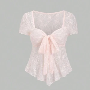 Ljusrosa spetsblus med rosett - Ny pris 89kr passar s/m  Superfin ljusrosa blus i spets med korta ärmar och stor rosett framtill. Blusen har blommigt mönster i tyget och är lätt transparent. Den har en feminin v-ringning och asymmetrisk nederkant som ger en extra söt vibe.