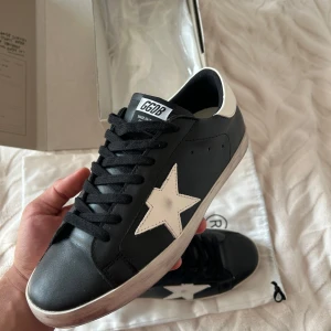 Golden Goose svartvita sneakers - Säljer ett par Golden Goose sneakers i svart och vita detaljer. Har använt dom bara 3-5 gånger, men annars är dom som nya. Priset går att diskuteras lite vid snabbt och smidigt affär 😊