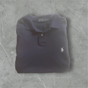 Mörkblå pikétröja från Ralph Lauren - Snygg mörkblå pique från Ralph Lauren perfekt till sommaren / skick 9,5/10 nästan ny / storlek L / Nypris ca 1400kr / kontakta via intresse eller annat och pris kan diskuteras!😊🙏