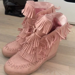 Rosa boots med fransar och kilklack - Säljer dessa supersnygga frans skor med kilklack. Ena snöret har gått sönder men det är ihop knutet och syns knappt, se bild.