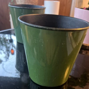 Två likadana Krukor   - Bilderna visar två gröna plastkrukor, perfekta för att plantera växter eller använda som dekoration i hemmet. Krukorna har en enkel, stilren design och passar bra för dig som vill ge dina växter en snygg look. Säljs i begagnat skick. Kan köpas i par eller per vas!