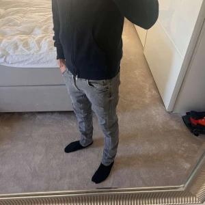 Lee jeans - Säljer ett par gråa jeans från Lee med klassisk femficksdesign och snygga detaljer vid fickor och midja. Jeansen har en smal passform och är tillverkade i stretchig denim för extra komfort. Perfekta för dig som gillar en modern och stilren look. Personen på bilden är 177! Köpta för 950