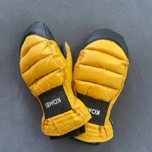 Gula tumvantar från Kombi - Helt nya & aldrig använda! Säljer ett par riktigt schyssta gula tumvantar från Kombi. De har svart förstärkning i handflatan och på fingertopparna, quiltad ovansida och elastisk mudd. Perfekta för kalla vinterdagar och riktigt snygga med sin färgstarka look.