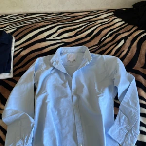 Linneskjorta  - Snygg ljusblå linneskjorta från lager 157 i klassisk modell med krage och knappar framtill. Skjortan har långa ärmar och är tillverkad i mjuk bomull, perfekt för en clean och stilren look.