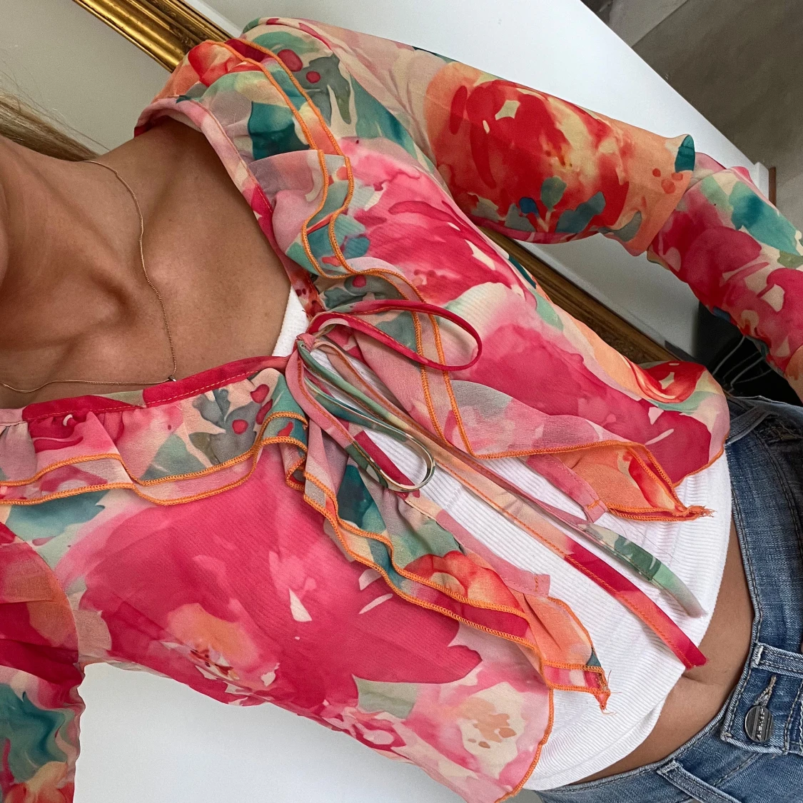 Blommig blus med snörning och volang