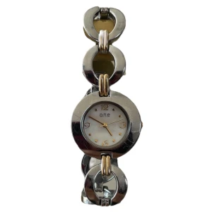 Silver - guld klocka från O.n.e - Silver-guld klocka med rund urtavla 🩶Urtavlans diameter: 3 cm. Urtavlans längd: 3 cm. Totala längd: 20 cm 