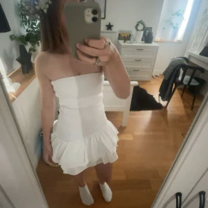 Vir klänning från Zara str S - Supersöt vit axelbandslös kortklänning från Zara str S. Använd 1 gång på midsommar förra året! Säljer för att den ej kommer till användning.